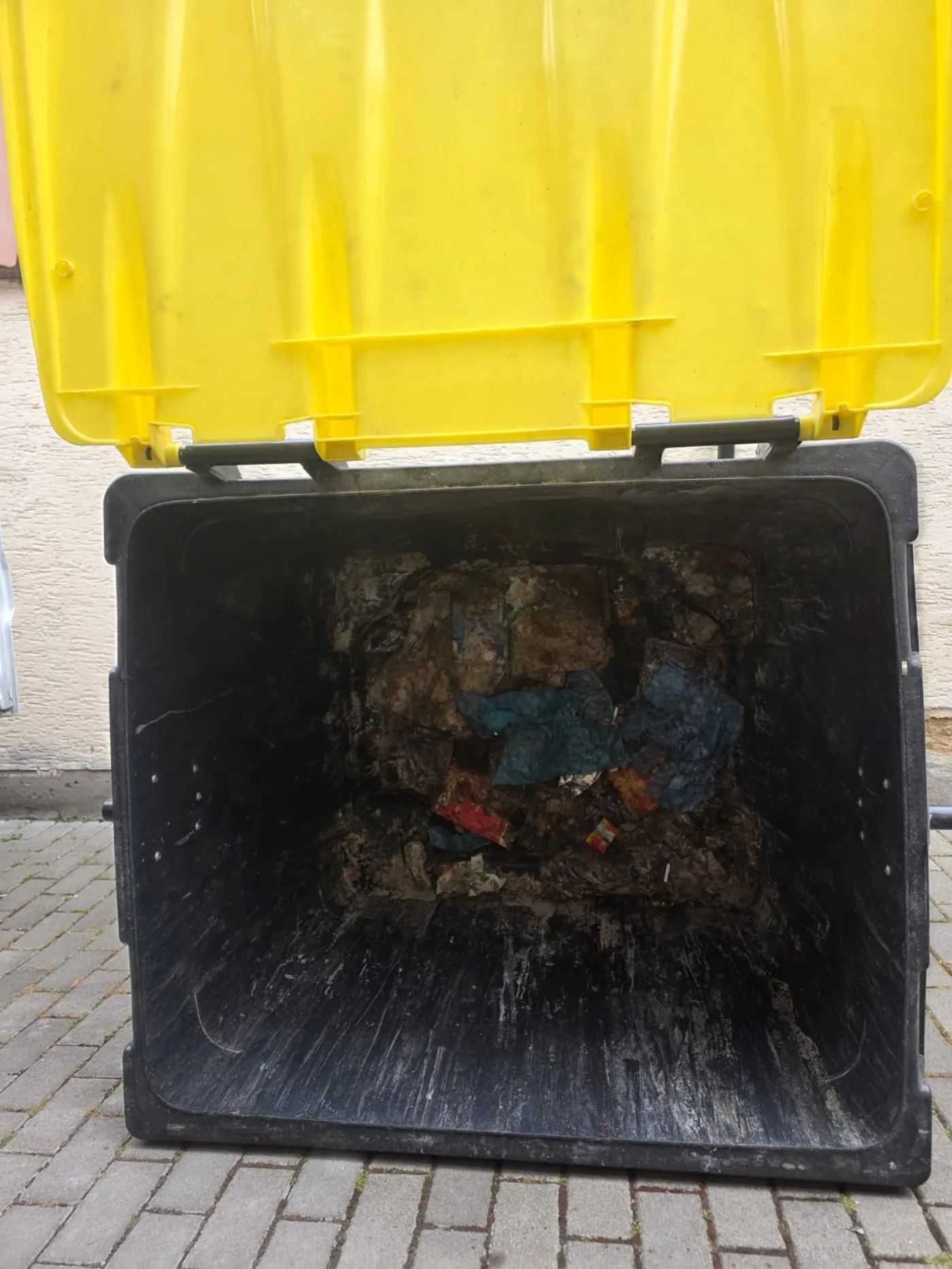 Stark verschmutzter 1100-Liter-Gewerbebehälter vor der Reinigung