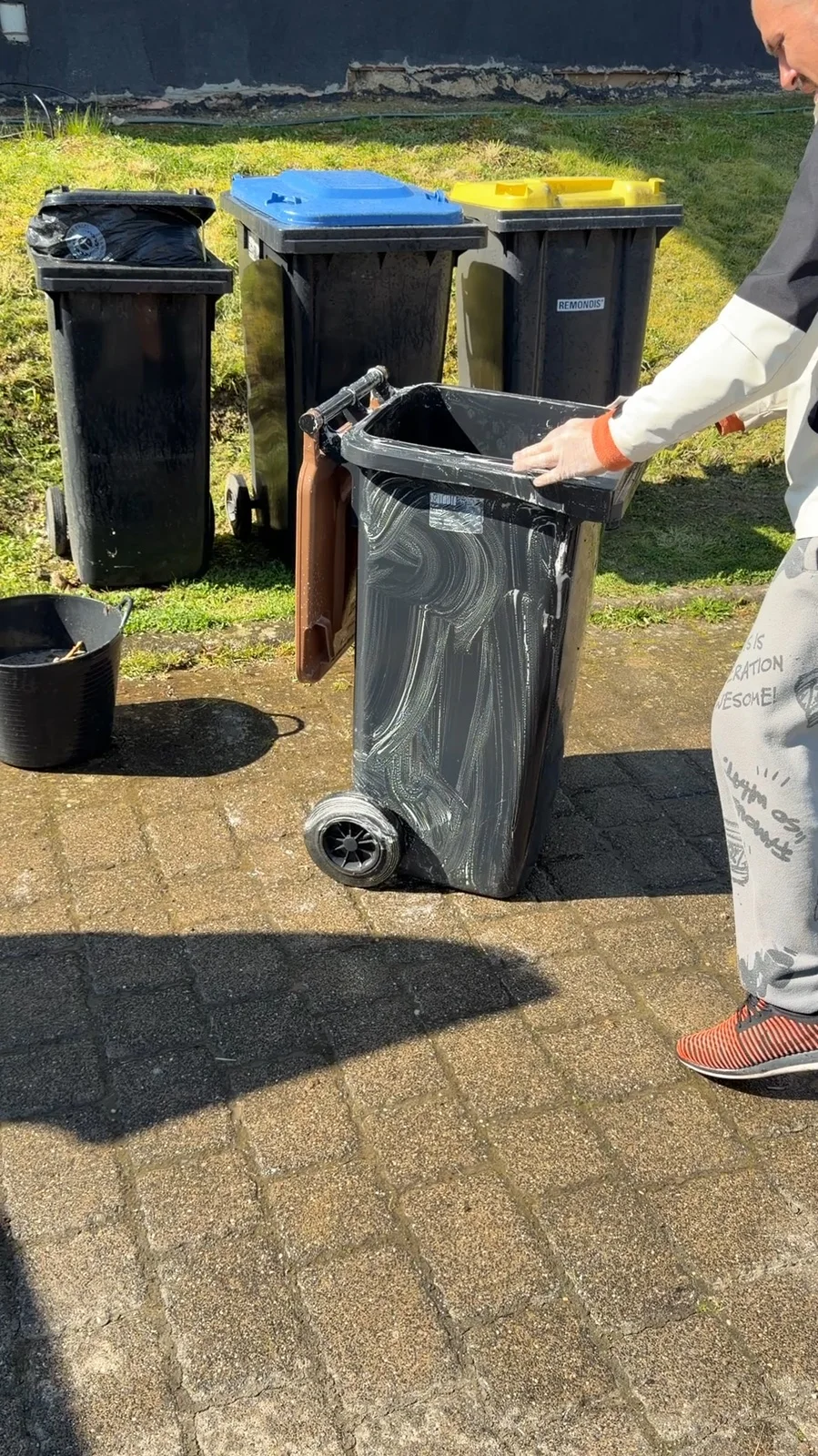 AhrBlitzGlanz Mitarbeiter bei der Reinigung einer Mülltonne